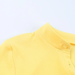 Close-up of bright yellow ribbed knit bodysuit featuring a buttoned neckline detail