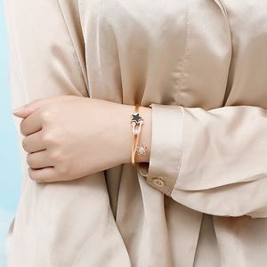 Close-up of star-shaped rose gold bracelet with black enamel and diamonds on wrist