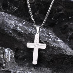 Men's stainless steel cracked cross pendant necklace with box chain over a dark stone background