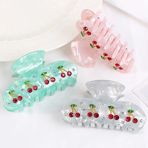 Three acrylic cherry hair claws with rhinestones in pink, green, and grey colors