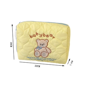 Detail view of yellow quilted pouch with baby bear embroidery and 22x18x7.5cm dimensions