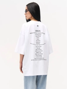 Close-up of oversized white cotton T-shirt with black religious lettering print on back