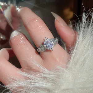 Detailed close-up of a zircon flower ring with purple gemstone and pavé accents