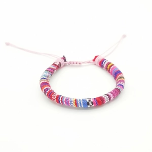Handmade bohemian colorful woven friendship bracelet with adjustable knot on white background