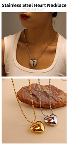 Detail view of heart pendant necklaces in gold and silver steel on a female model