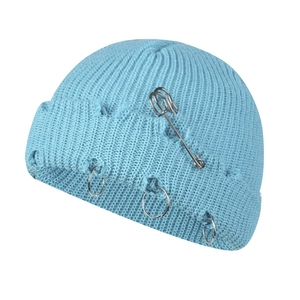 Detail of light blue distressed knit beanie with metal rings and safety pin accessory