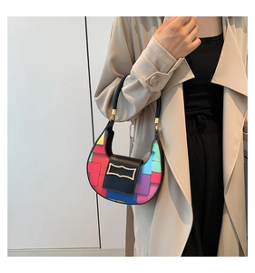 Detail of color-block crescent bag featuring vibrant geometric patterns and metal buckle