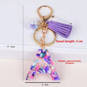 Detail view of resin letter A keychain with purple tassel and dimension markings
