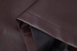Detailed close-up of premium dark brown PU leather jacket with fine stitching and lining