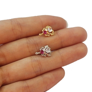 Primo piano di orecchini a lobo con cuore in zircone color oro e argento sul dito