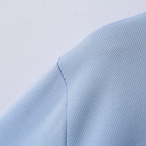 Close-up of light blue polo shirt shoulder seams with breathable mesh fabric texture