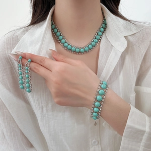 Gros plan d'un ensemble de bijoux bohèmes en résine turquoise avec collier et boucles