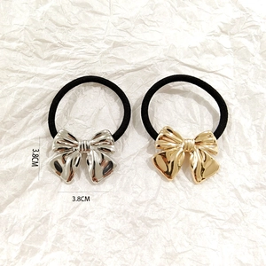 Close-up of gold and silver hollow bow hair rings with 3.8cm size dimensions shown