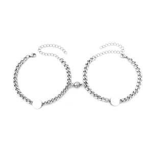 Close-up of magnetic heart clasp on silver Cuban link couple bracelets in polished steel