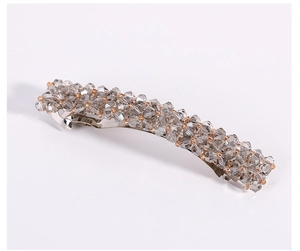 Détail de perles de cristal coréennes et billes dorées sur une pince à cheveux en métal