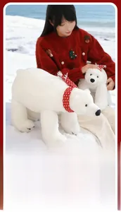 White polar bear plush toy set with red scarves in festive winter outdoor setting