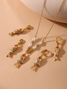 Detail view of gold stainless steel necklace and fish pendant with colorful enamel and pearls