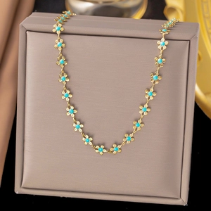 Detail of golden flower link necklace with turquoise centers on luxury gift box