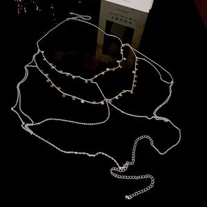 Detailed view of layered body chain featuring gold sequins and adjustable lobster clasp