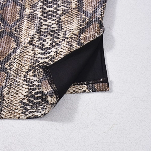 Détail de sequins à motif serpent et fente latérale sur cette robe moulante dos nu