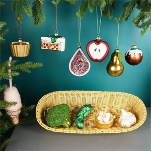 Painted glass Christmas ornaments in fruit and vegetable shapes hanging on pine branches