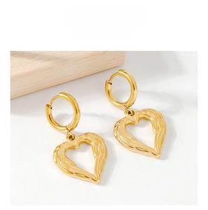 Détail de boucles d'oreilles cœur ailé plaquées or 18K avec textures gravées 3D