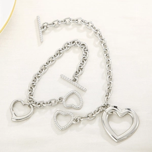 Detail view of silver stainless steel chunky link necklaces with heart pendants and OT clasps