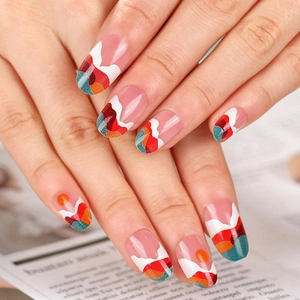 Short round press-on nails with sunset landscape design in vibrant orange and green colors