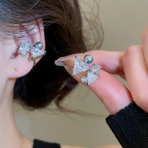 Detail of silver bow ear cuff with sparkling zircon stones and grey pearl accent