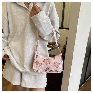 Close-up of pink fabric handbag featuring cartoon bear patterns and bow tie details