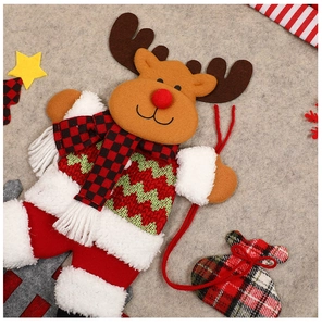 Detail view of a reindeer Christmas ornament with knit sweater and plaid scarf texture