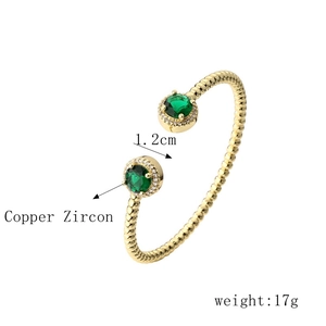 Detail view of gold open bangle with green zircon stones showing dimensions and weight