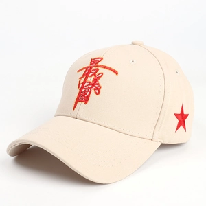 Close-up of red star and artistic Chinese embroidery on a beige cotton baseball cap