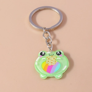 Close-up of a cute green frog acrylic keychain holding a rainbow heart on pink background