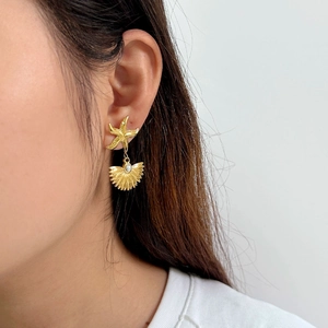 Detailed view of ocean-style starfish earrings with shell pearls on model