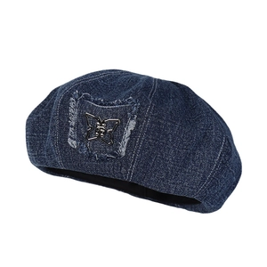 Dark blue denim beret with a stylish metal butterfly emblem and frayed edge patch