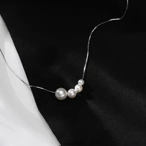 Elegant minimalist silver necklace with four gradient white pearls on black silk background