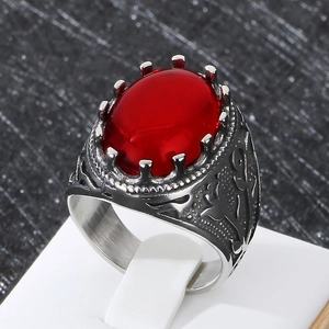 Detailed view of vintage silver ring with red gemstone and intricate floral carvings