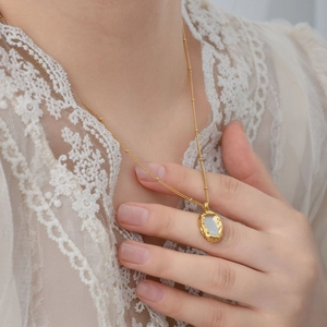 Vintage 18K gold plated necklace with irregular oval mother of pearl pendant on model