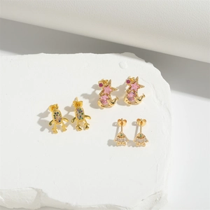 Elegant gold bear and animal earrings set with zircon stones on a white stone base