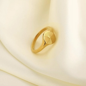 Minimalist gold oval signet ring featuring radiant sunburst pattern engraving for women