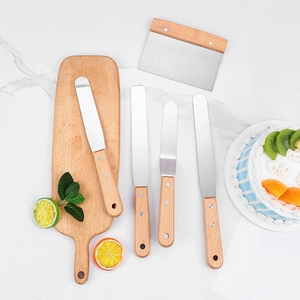 Stainless steel baking spatulas and scrapers set with wooden handles on marble