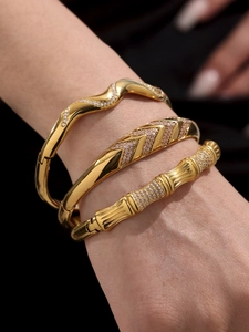 Close-up of three 18k gold plated stainless steel bangles with zircons on a model wrist