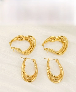 Detail of 18k gold plated stainless steel multi-layered heart and oval hoop earrings