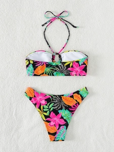 Flat lay of a two-piece tropical floral bikini with halter top and high-cut bottom
