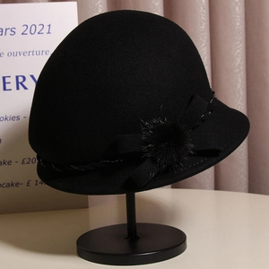 Detail of wool cloche hat with a bow and soft mink fur ball decoration