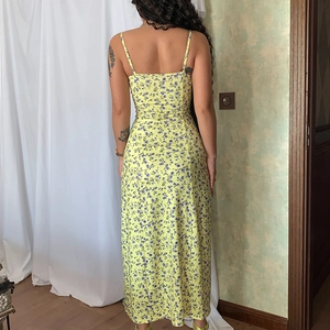 Back view of a yellow floral slip dress with a blue flower pattern and back zipper detail
