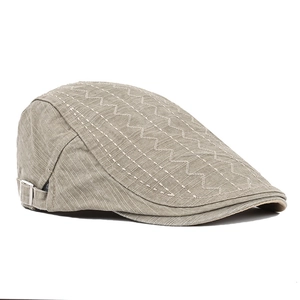 Detail of khaki cotton flat cap featuring wavy stitching and metal side buckle