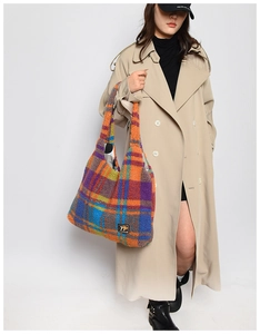 Model showing large colorful plaid plush tote bag with vibrant teddy fleece texture