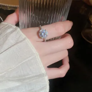 Elegant Korean style halo zircon ring with round center stone on white pleated background